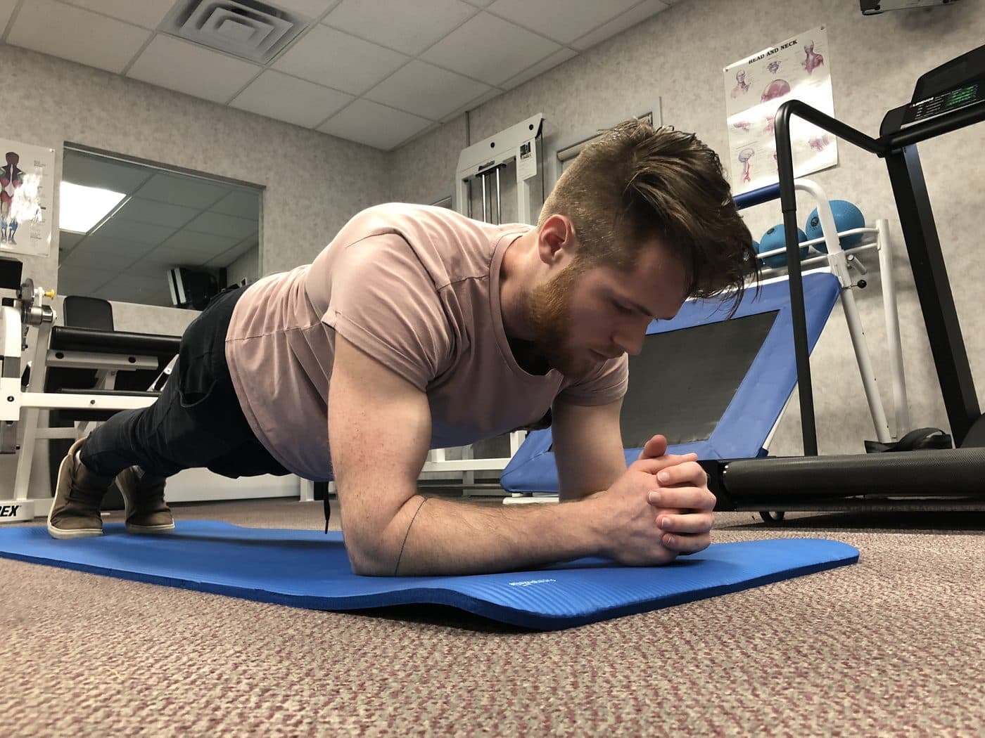 Patient holding a plank on an exercise mat