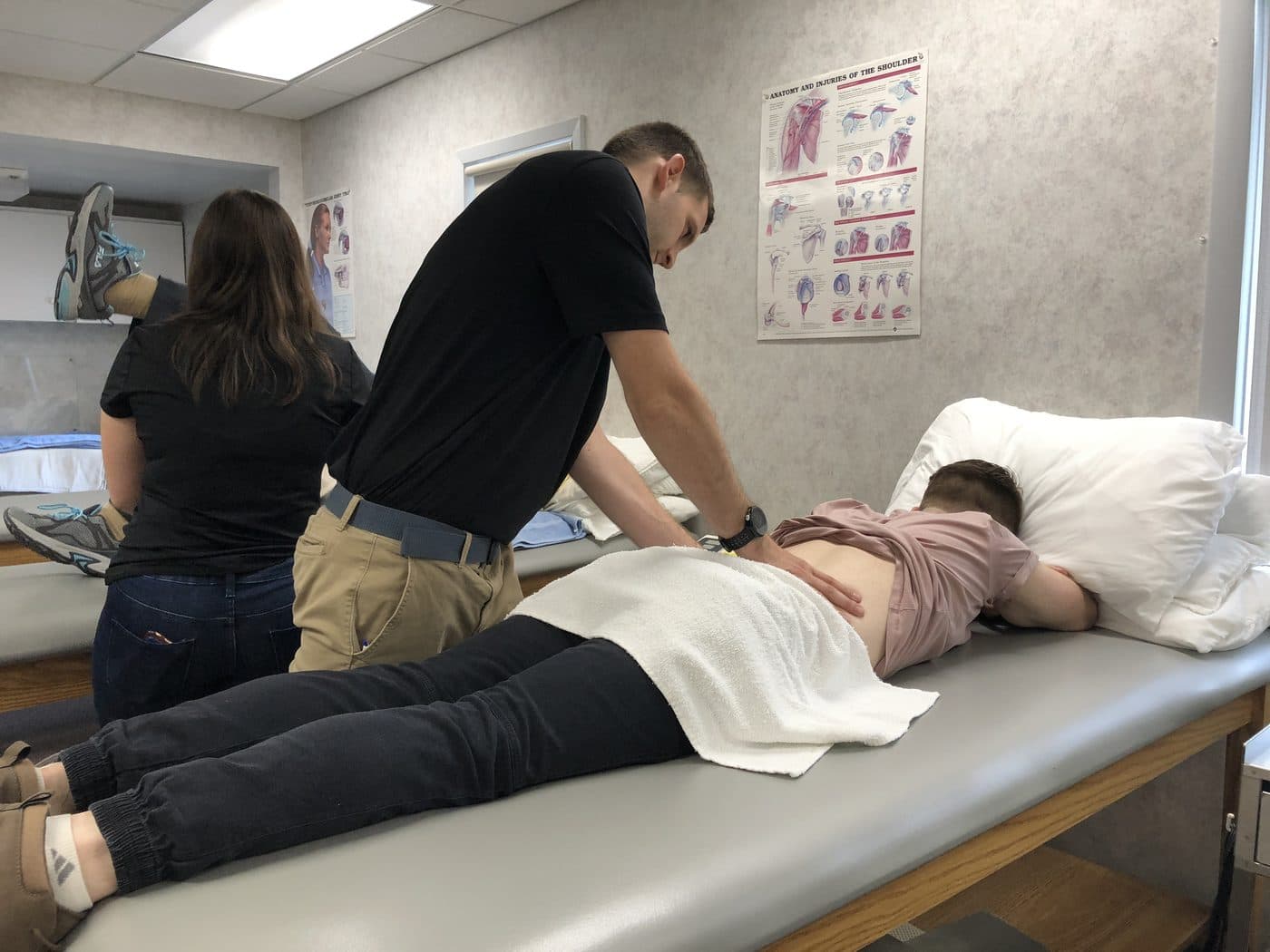 Two therapists treating a patient's back